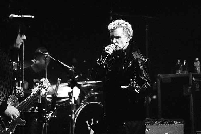 Musician performing on stage with a band.