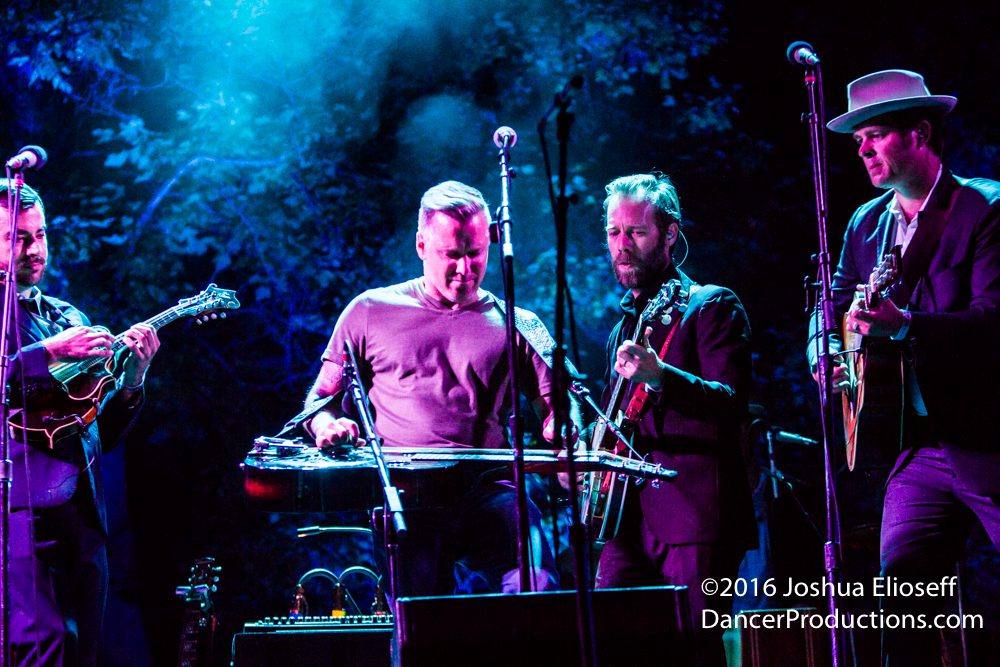 Band performing on stage with blue lighting.