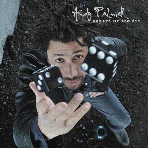 Person throwing black dice upward, artistic angle.
