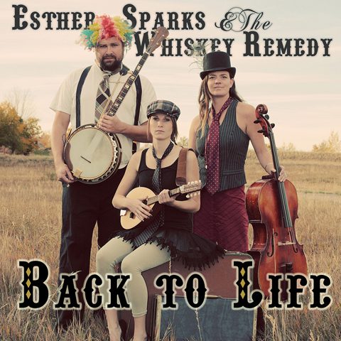 Three musicians in a field with instruments.