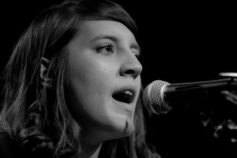 Singer performing on stage with microphone.