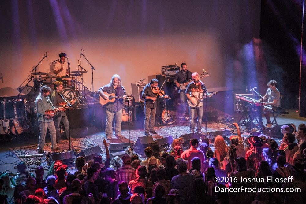 Band performing live on stage with audience.