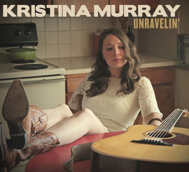 Woman relaxing with guitar in kitchen.