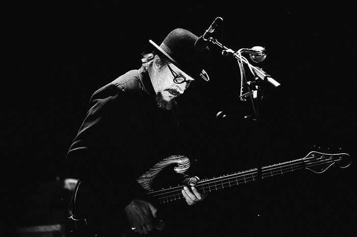 Musician playing bass guitar on stage.