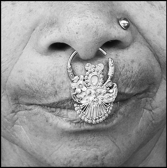 Nose adorned with intricate silver nose ring.