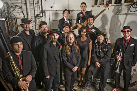Band posing together in industrial setting.
