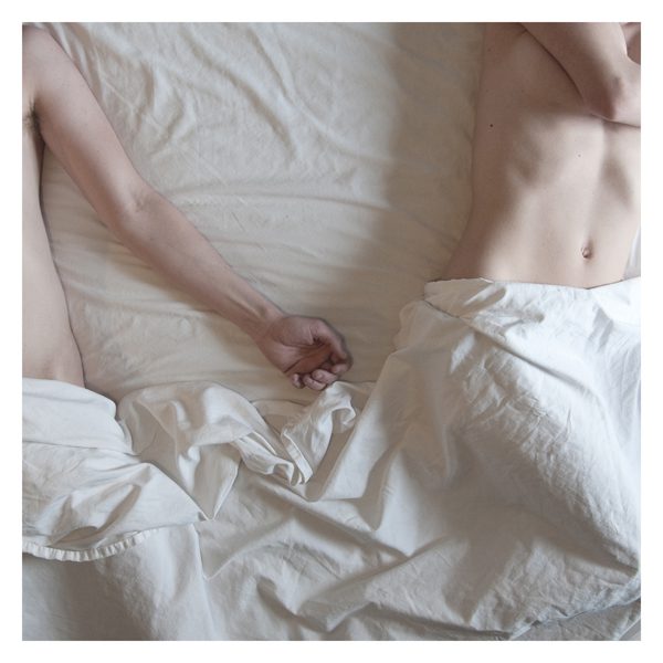 Two people lying on a bed.