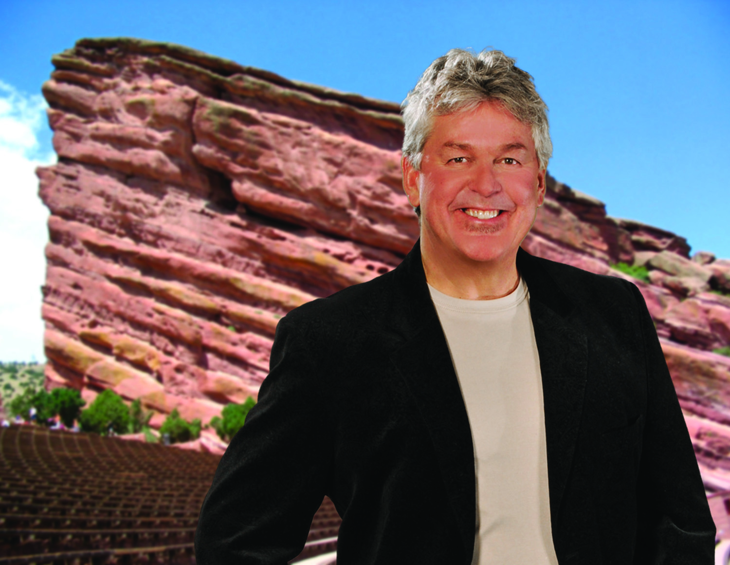 Man smiling in front of red rock formation.