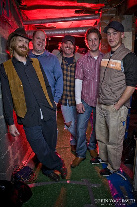 Five men posing in casual attire.