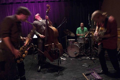Jazz band performing energetically on stage.