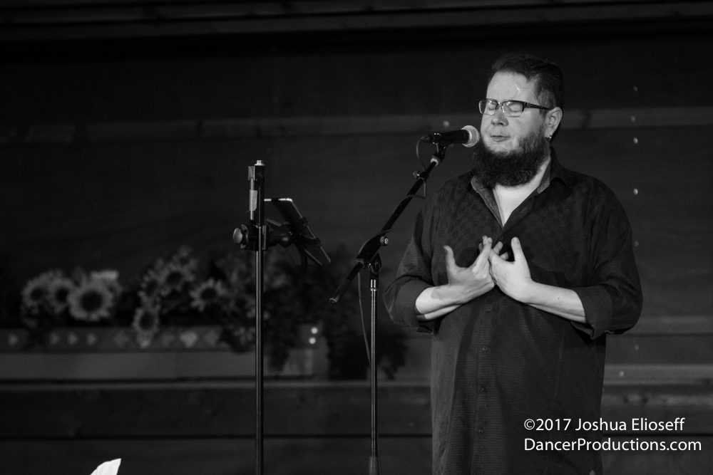 Man singing passionately into a microphone.