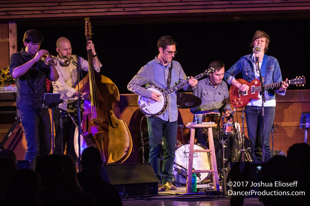 Band performing with various musical instruments.