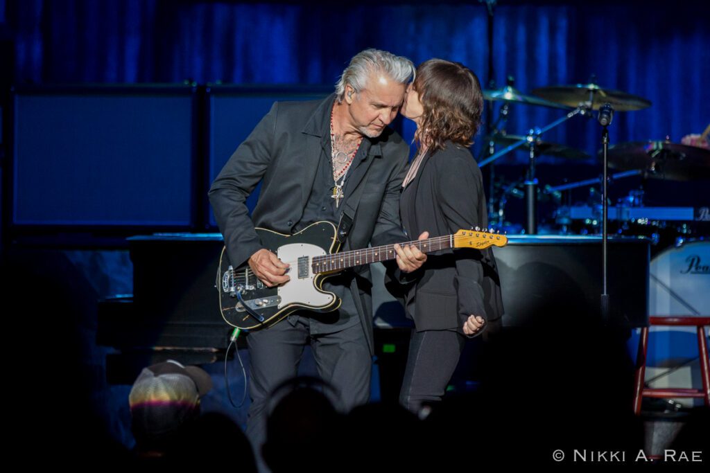 Musicians performing passionately on stage together.
