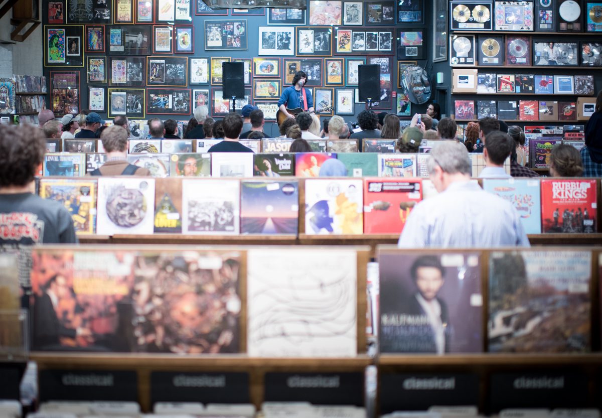 Record store event with audience and albums.