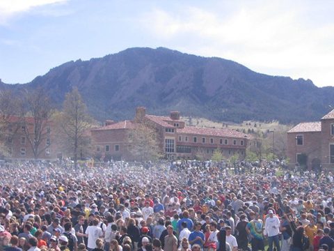 Large crowd gathered outdoors near mountains.