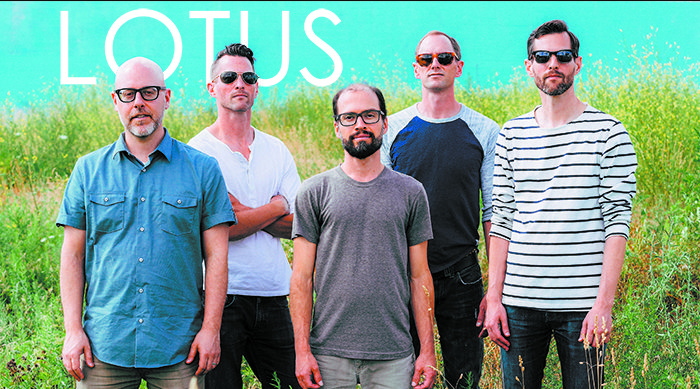 Five men standing in a grassy field.