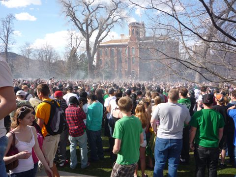 Crowd gathering outdoors near historic brick building.