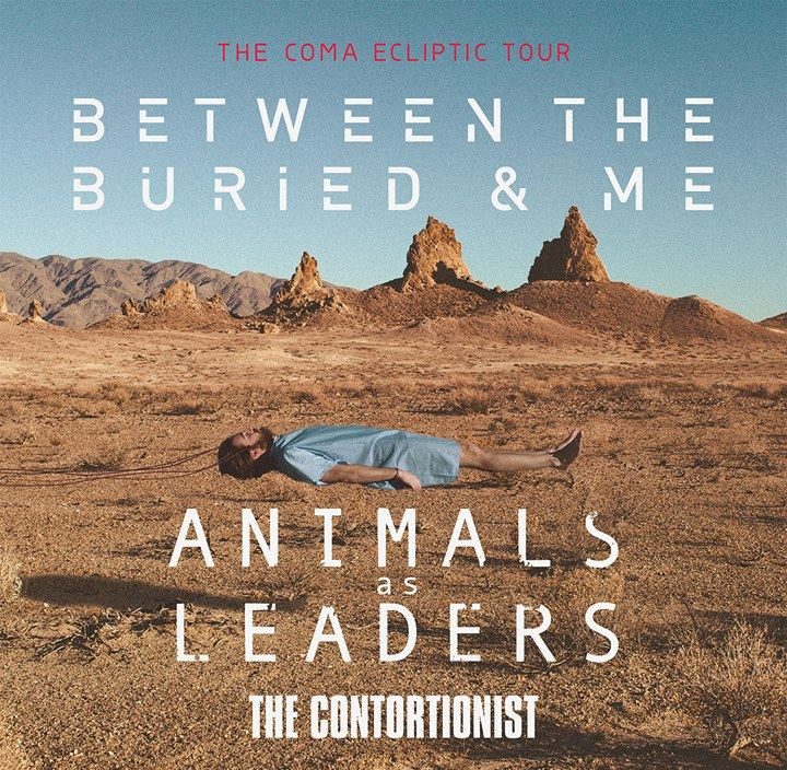 Person lying in desert, band names visible.