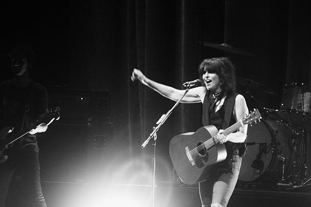 Singer performing on stage with guitar.