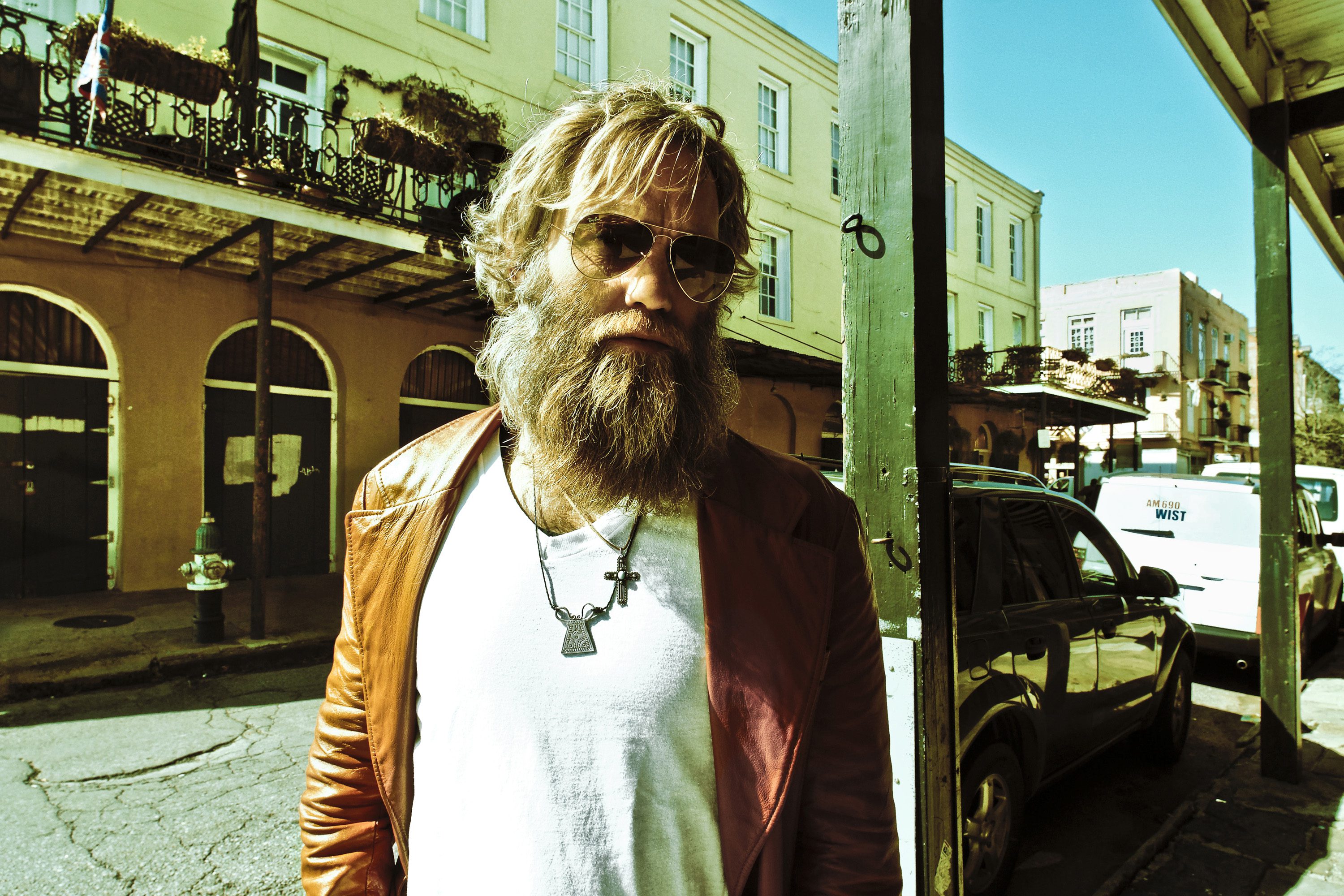 Man with sunglasses and beard on street.
