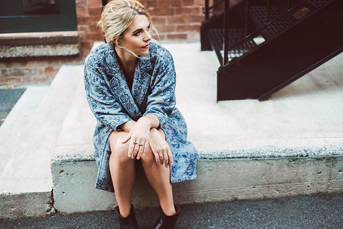 Woman sitting on concrete steps, looking away.