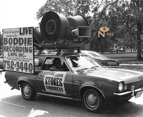 Car with loudspeakers and political campaign signs.