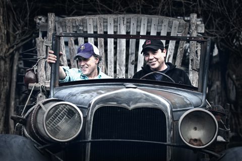 Two people sitting in vintage car.