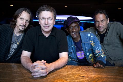 Four men sitting at a wooden table.