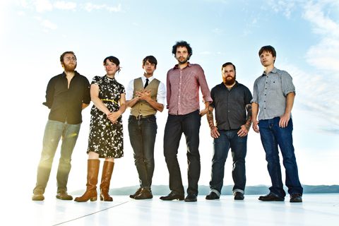 Six people standing in a row outdoors.