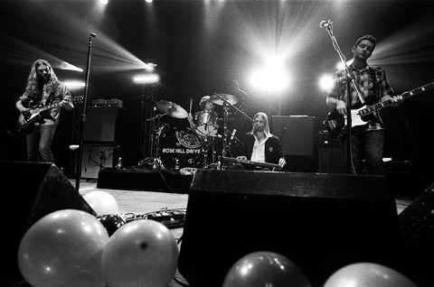 Band performing on stage with balloons below.