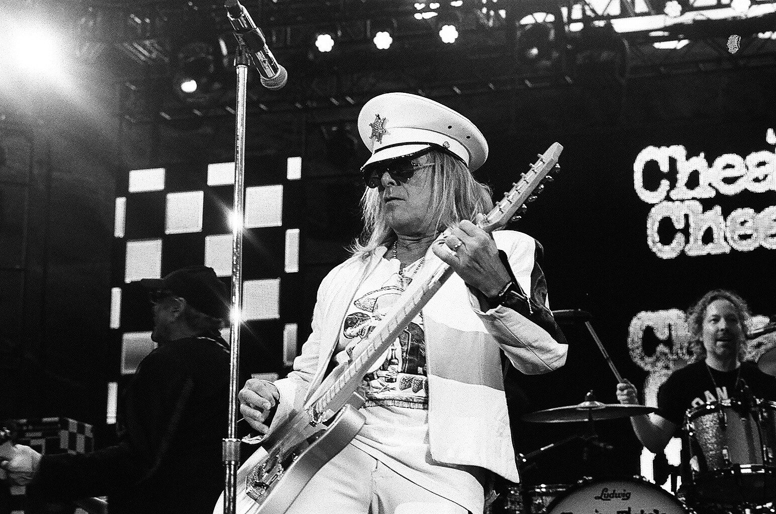 Guitarist performing on stage with band.