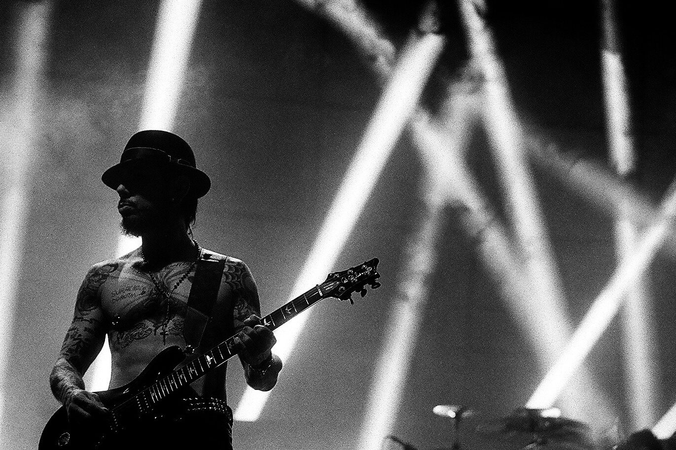 Guitarist performing under dramatic stage lights.