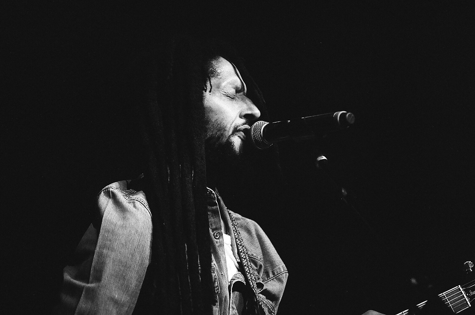 Singer performing with microphone on stage.