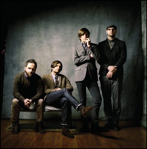 Four men posing in smart casual attire.