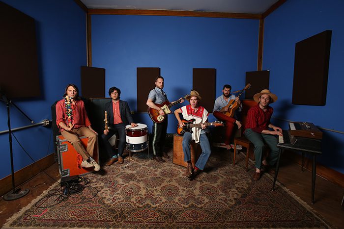 Band rehearsing in a blue music studio.