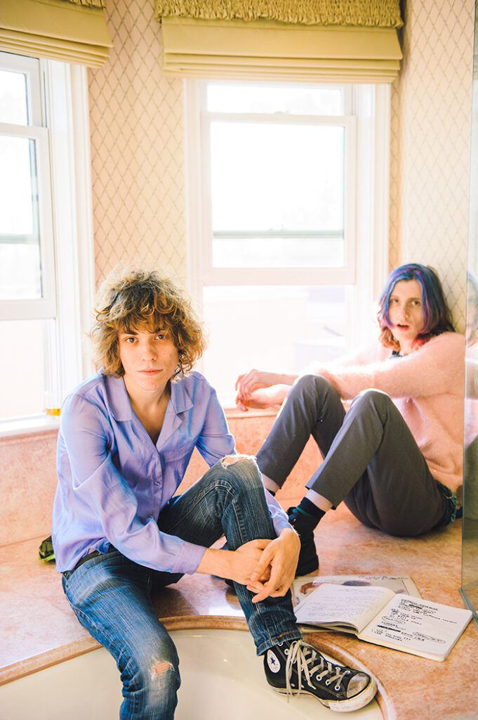Two people sitting near a sunlit window.