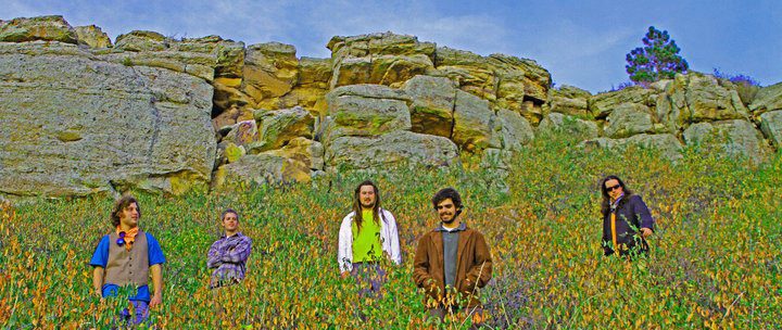 People standing in a colorful rocky landscape.