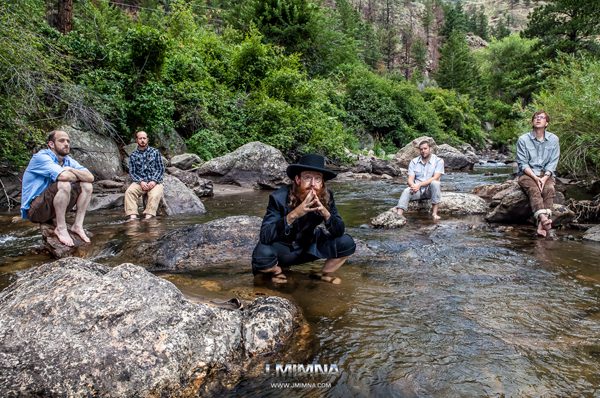 Group of people sitting on river rocks.