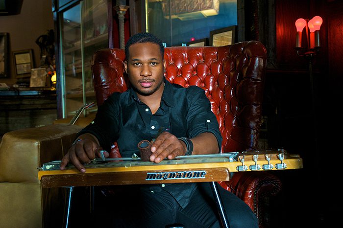 Musician seated with a lap steel guitar.