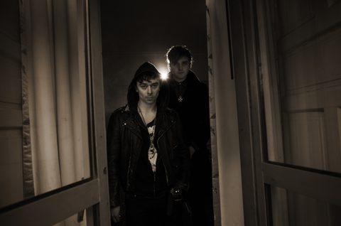 Two people standing in dimly lit doorway.