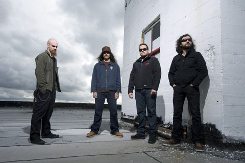 Four men standing on a rooftop.