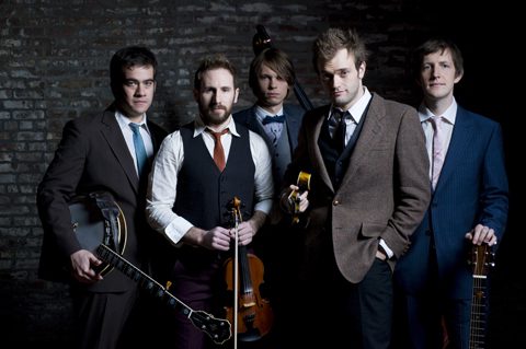 Five men posing with musical instruments.