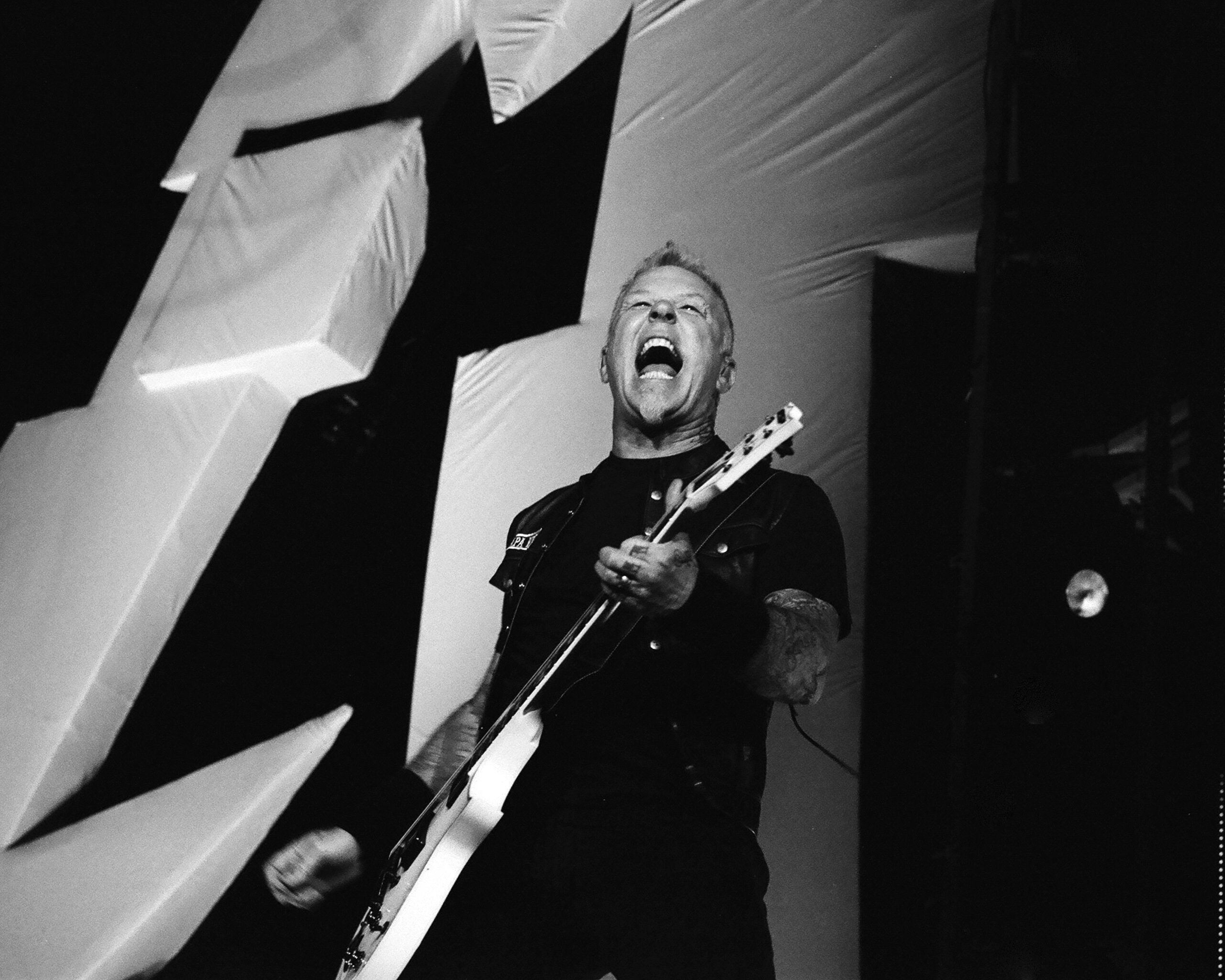 Musician passionately playing guitar on stage.