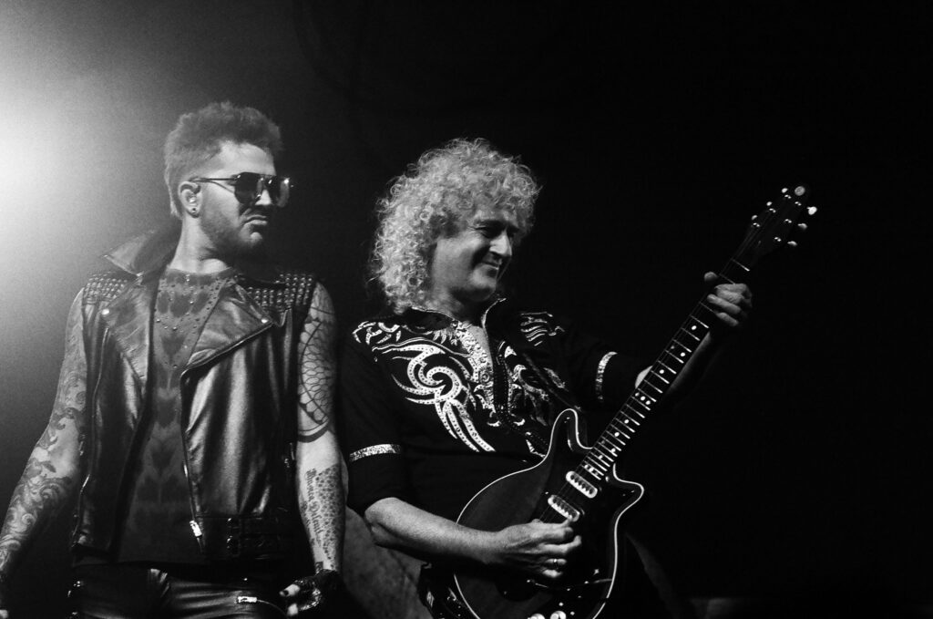 Two musicians performing on stage with guitars.