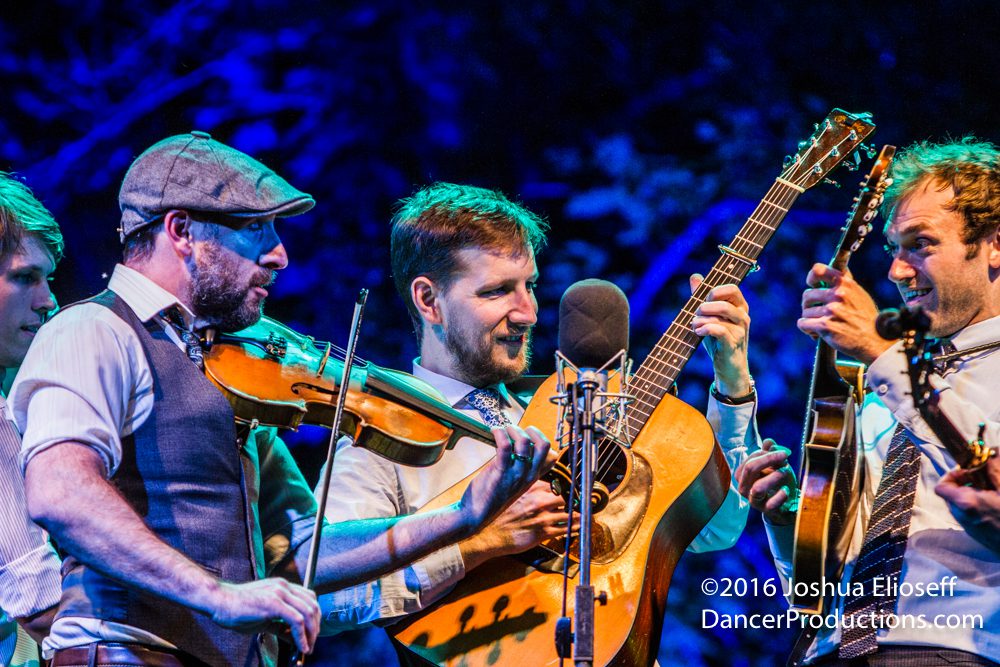 Musicians performing with violins and guitar.
