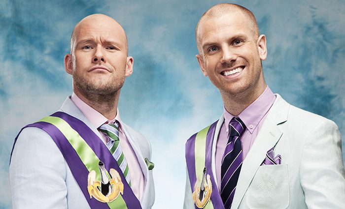 Two men in suits with colorful sashes.