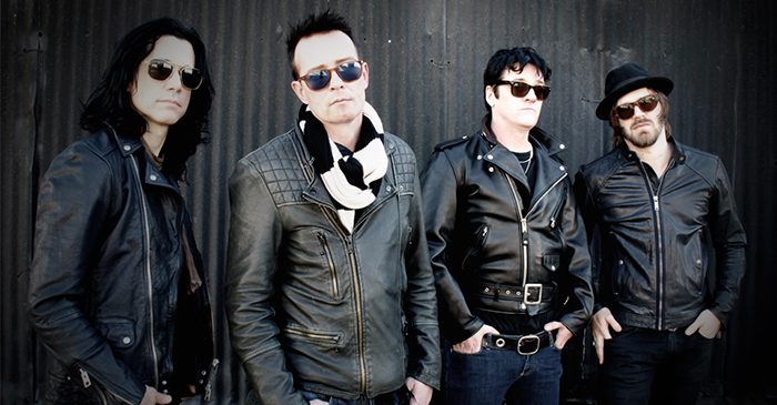 Four men in leather jackets and sunglasses.
