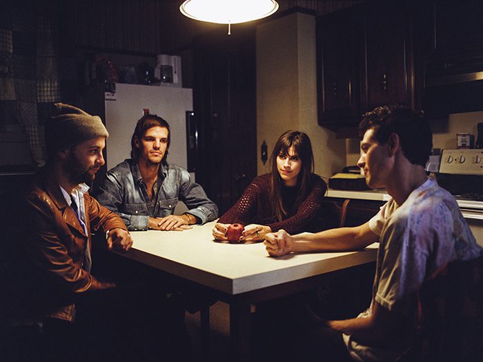 Four people sitting at a kitchen table.