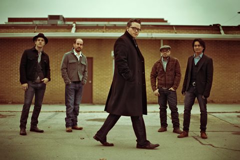 Five men standing in casual outdoor setting.