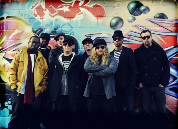Group of people in front of graffiti.
